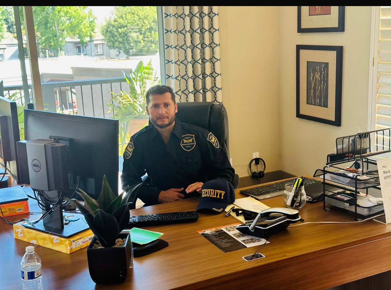 Aquila Private Security officer at office desk with monitors
